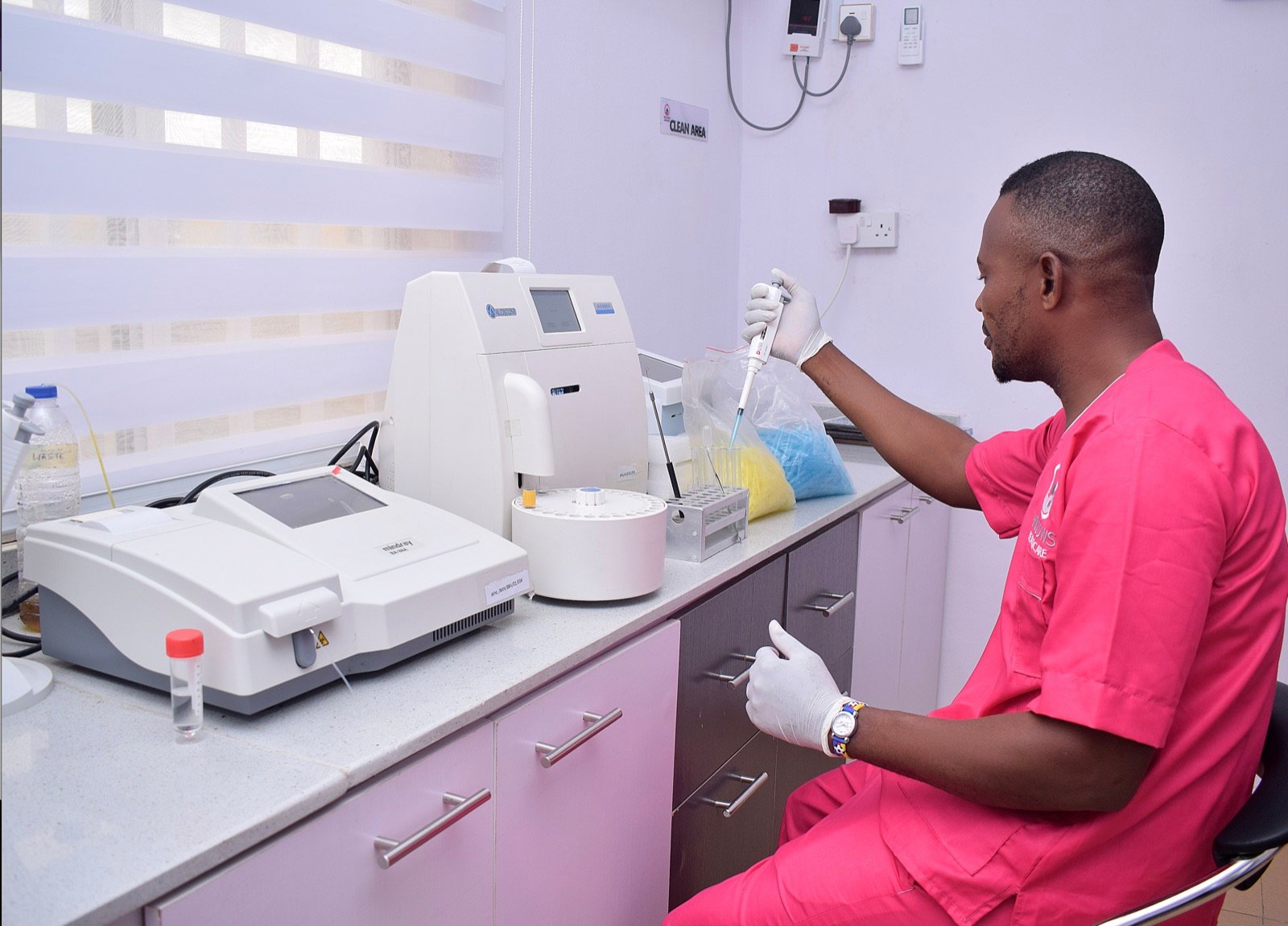 A Willows Healthcare scientist running samples on an automated analyser